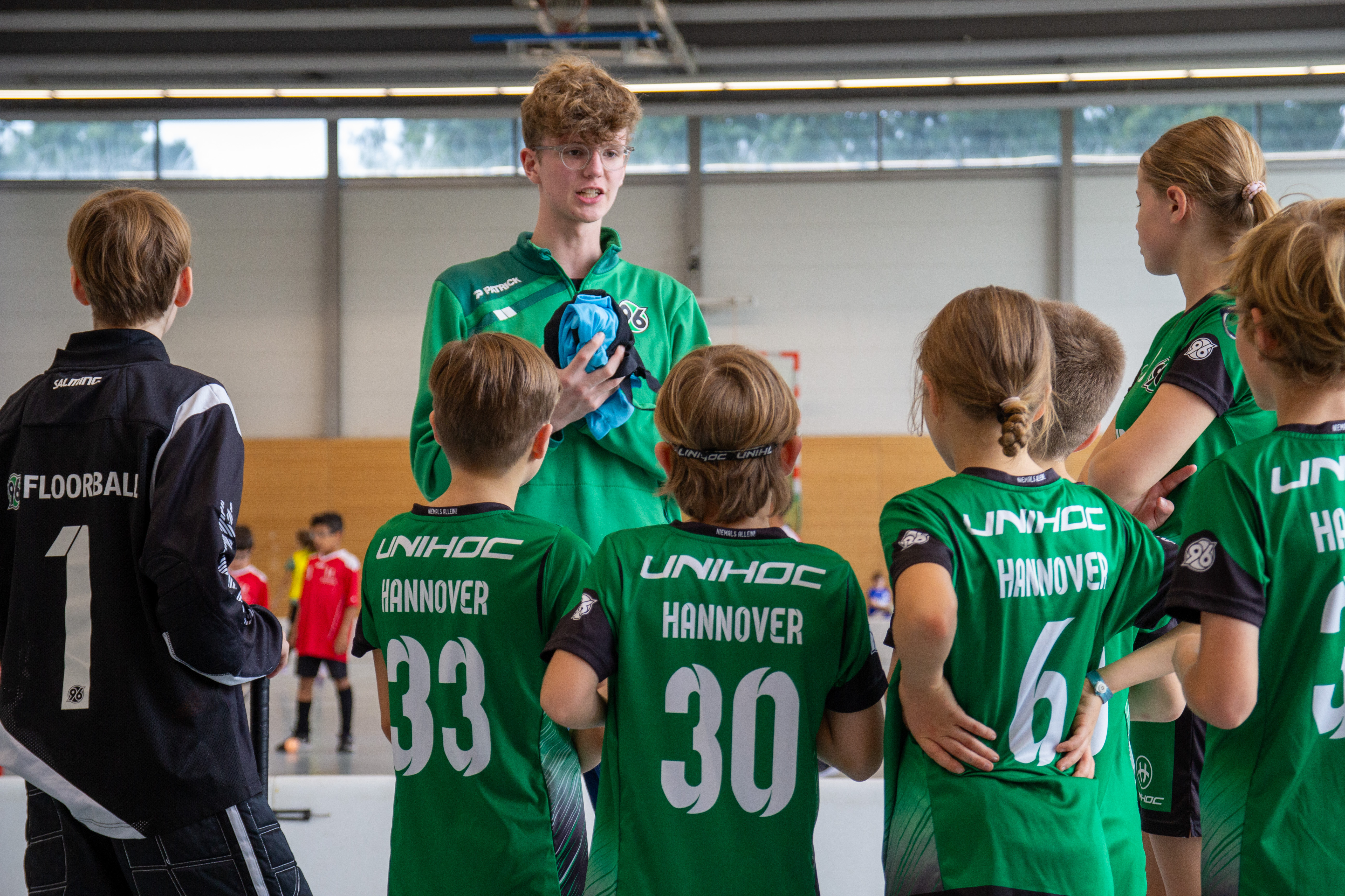 Der Trainer gibt seinen SpielerInnen Anweisungen.
