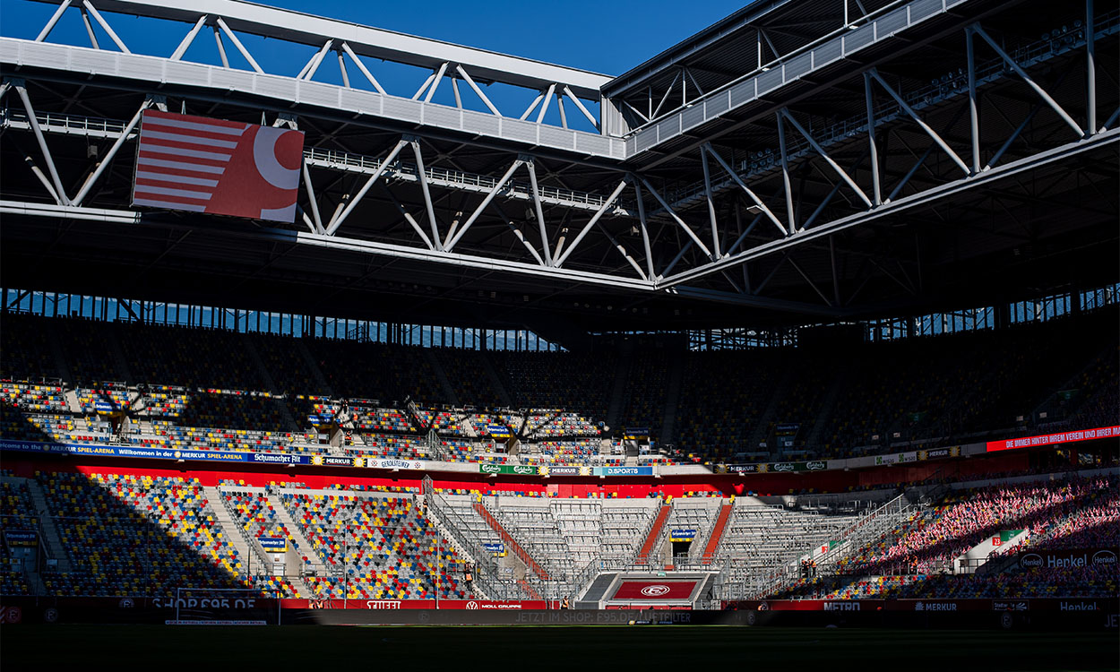 Der Gästeblock im leeren Düsseldorfer Stadion, die Sonne scheint rein.