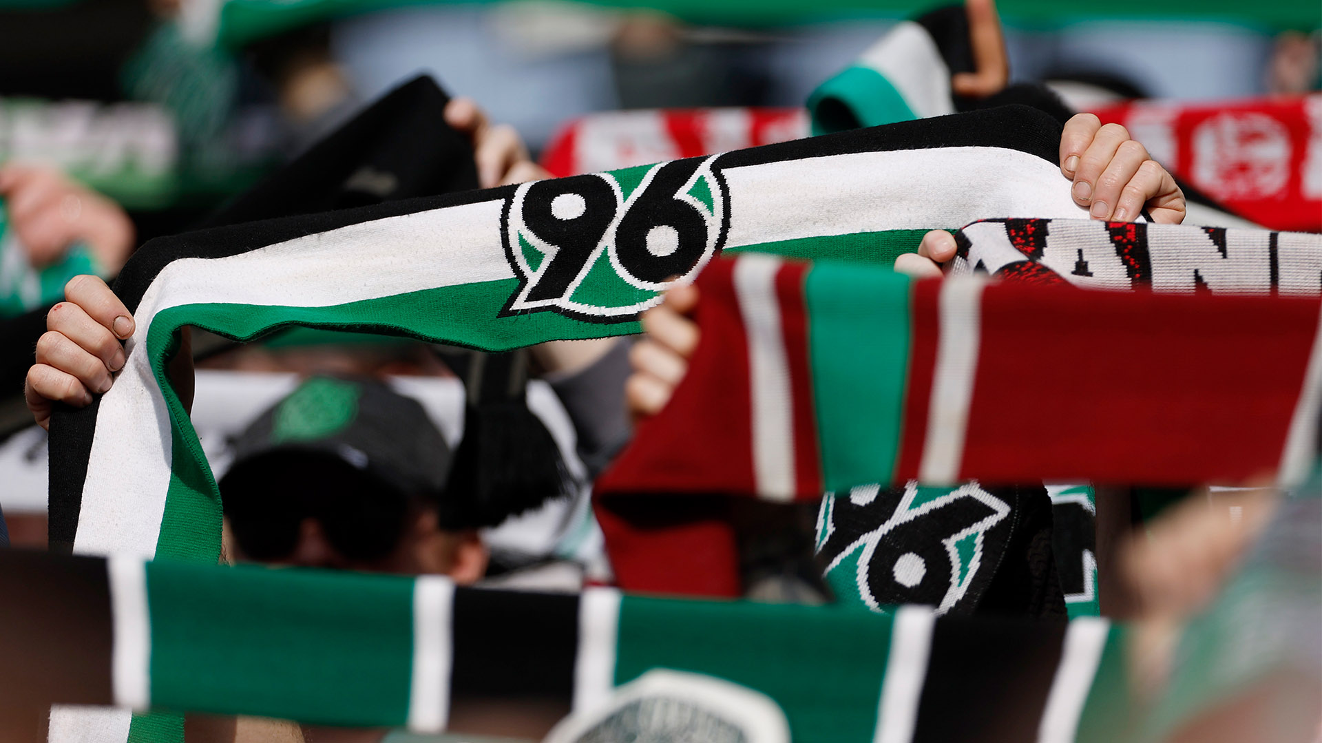 96-Schals werden in die Höhe gehalten.