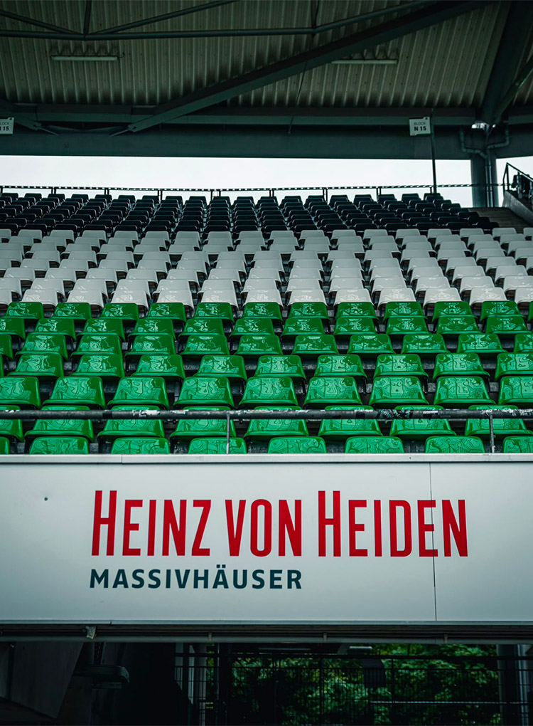 Schwarze, weiße und grüne Sitzschalen im Stadion.