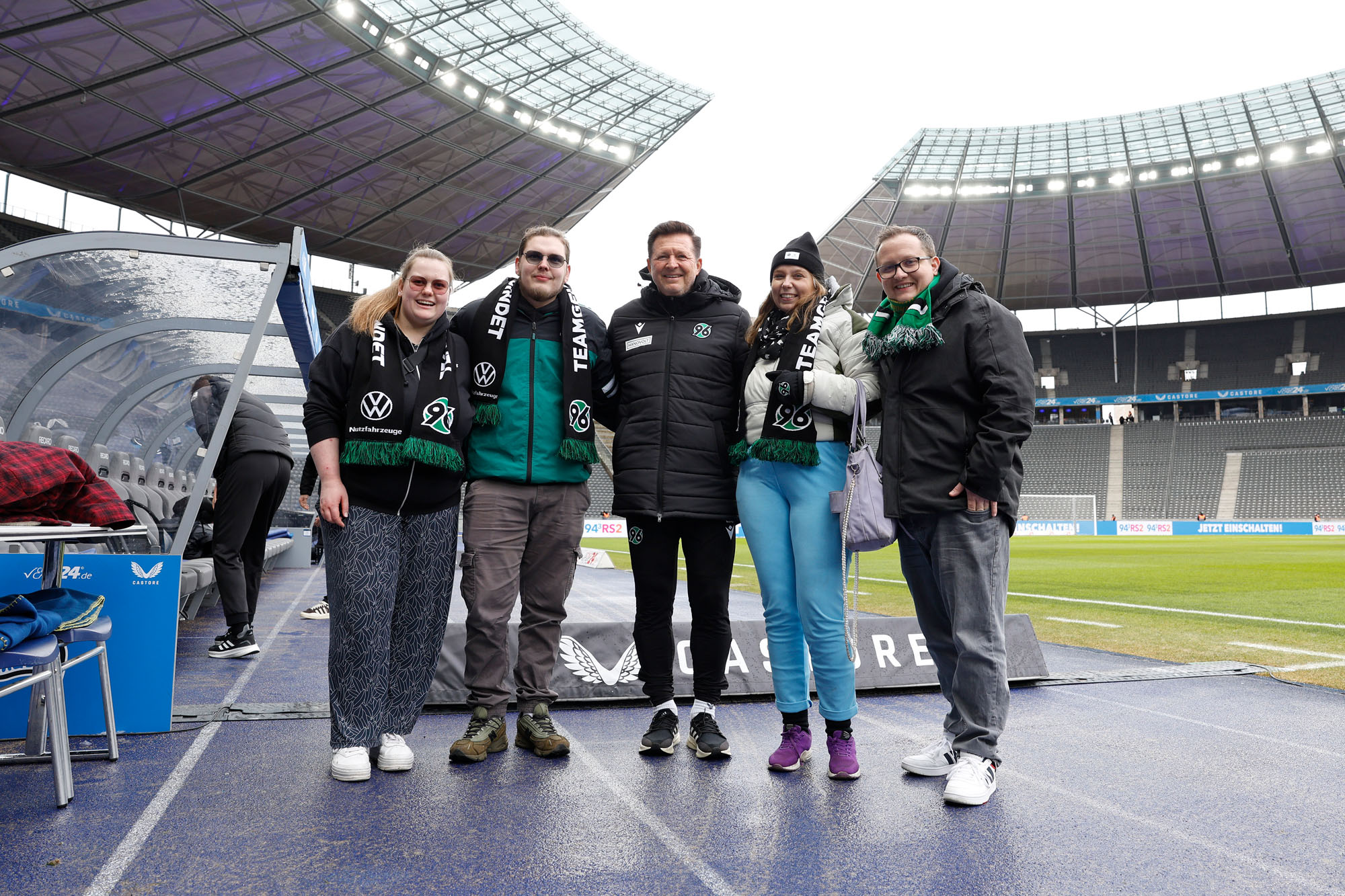 Die vier Fans posieren im Olympiastadion mit Trainer Christian Titz.