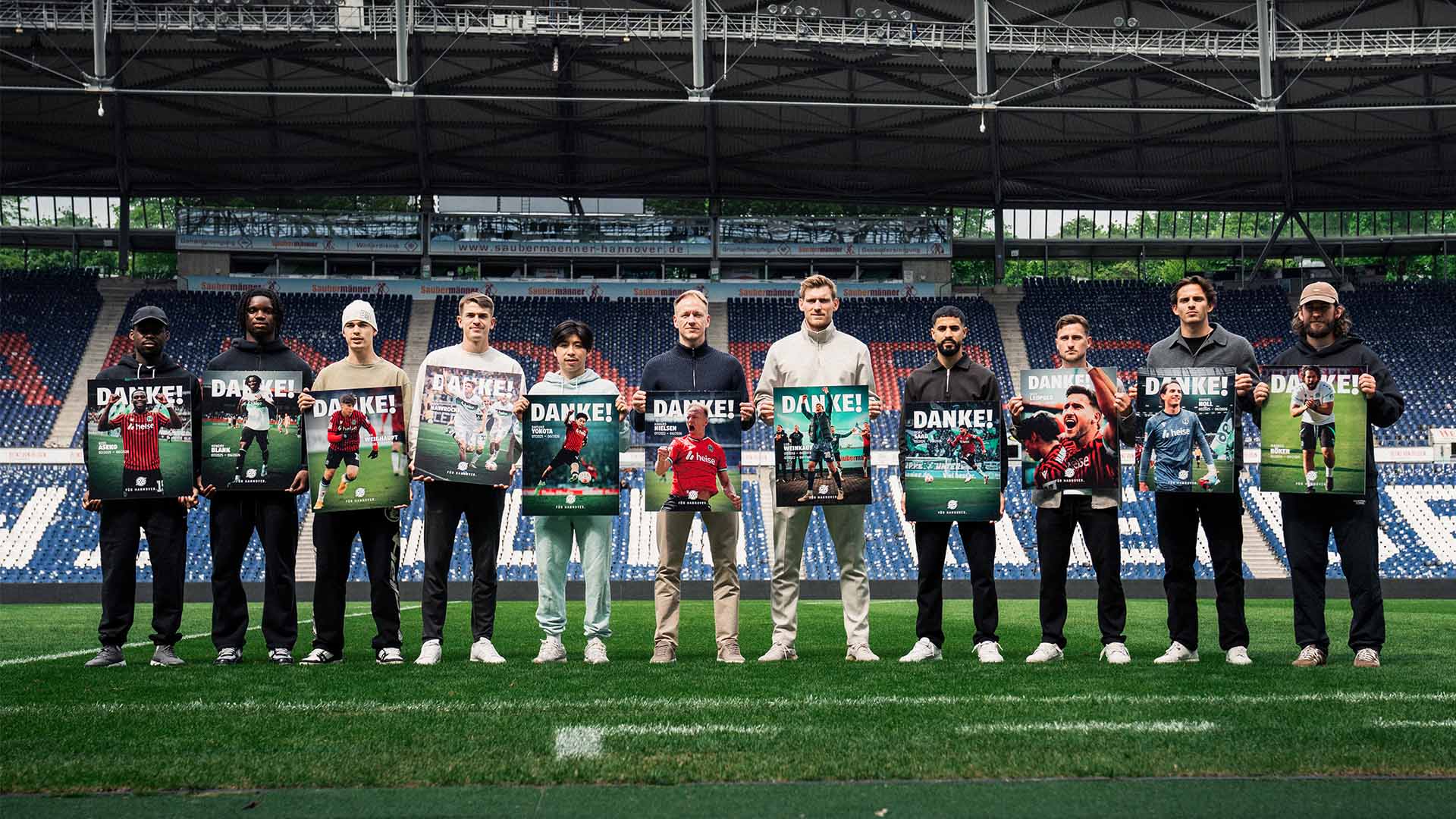 Elf Personen stehen im Stadion, alle halten Grafiken zum Abschied vor sich.