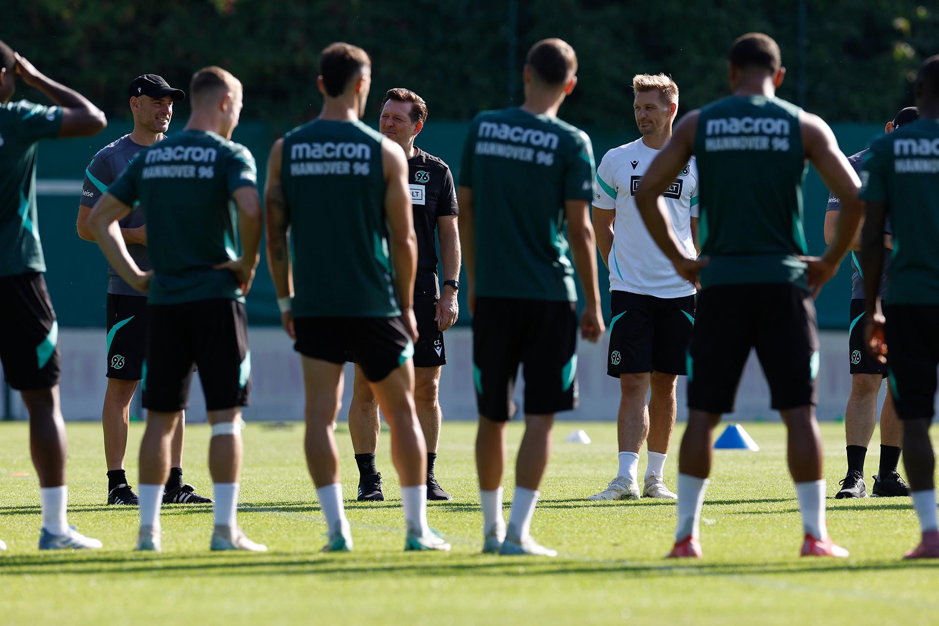 Kreis auf dem Platz: Felix Sunkel, Christian Titz und Michael Ratajczak sind von vorne zu sehen, einige Spieler von hinten. 