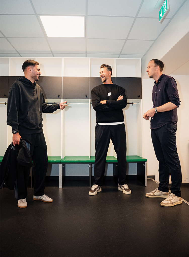 Can Ünal, Julian Battmer und Sandro Wagner stehen in einer Kabine und lachen.
