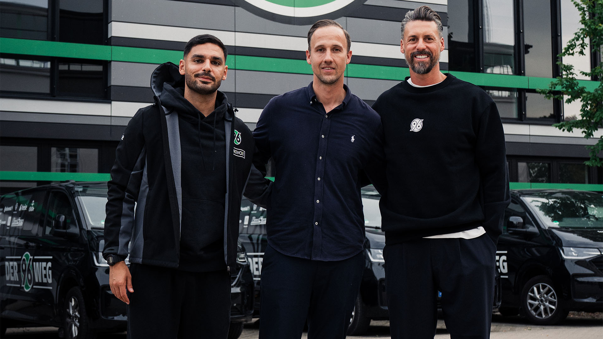 96-Cheftrainer Sandro Wagner, Co-Trainer Can Ünal und Akademiedirektor Julian Battmer stehen vor der 96-Akademie.