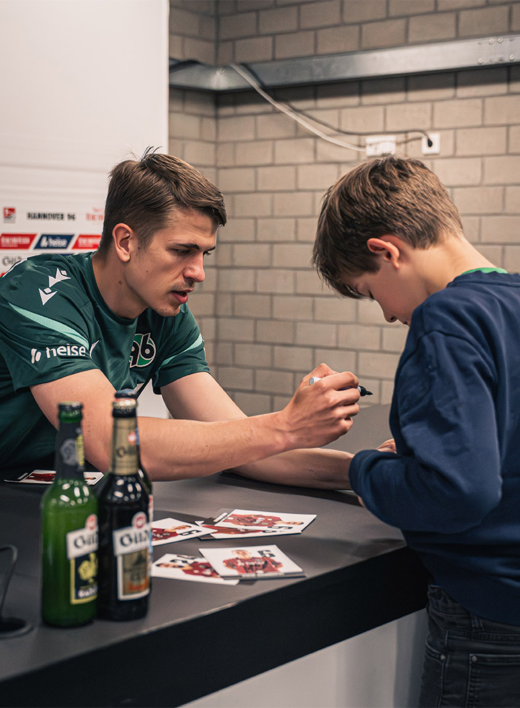 Maik Nawrocki unterschreibt das Shirt eines Jungen.