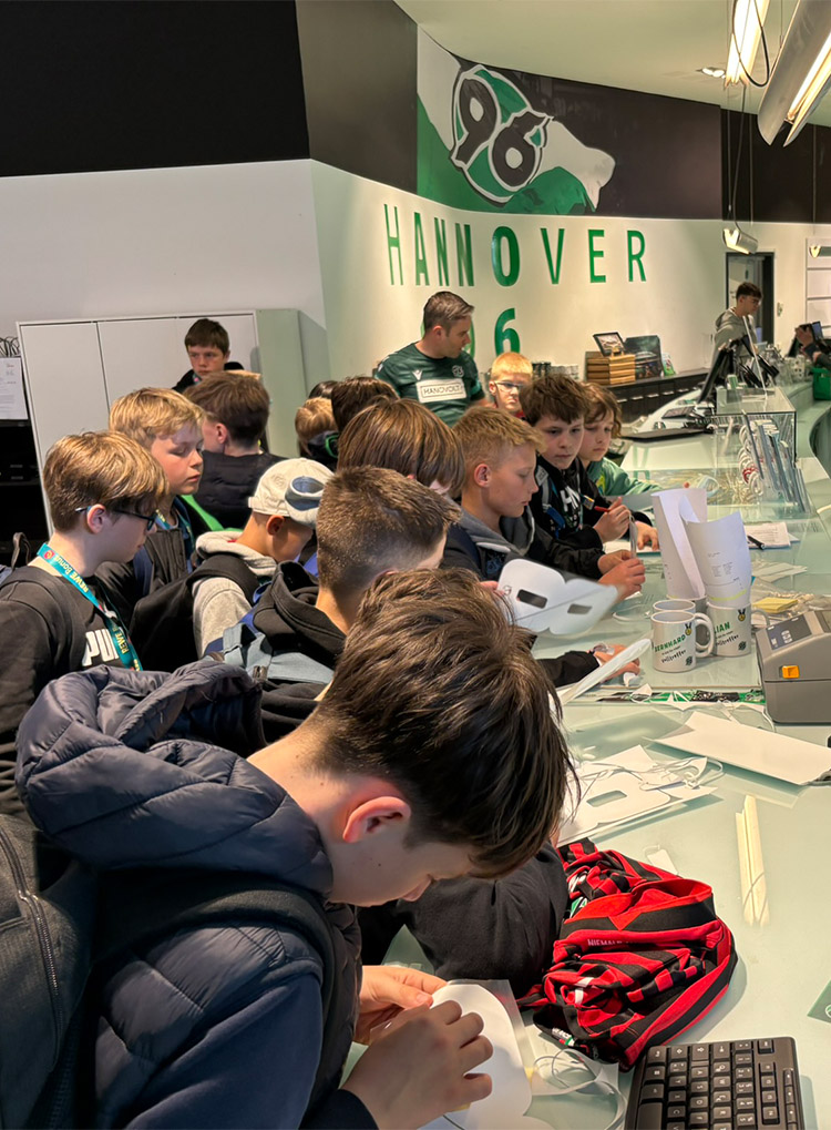 Die Kinder scharen sich um den Tresen im Fanshop.