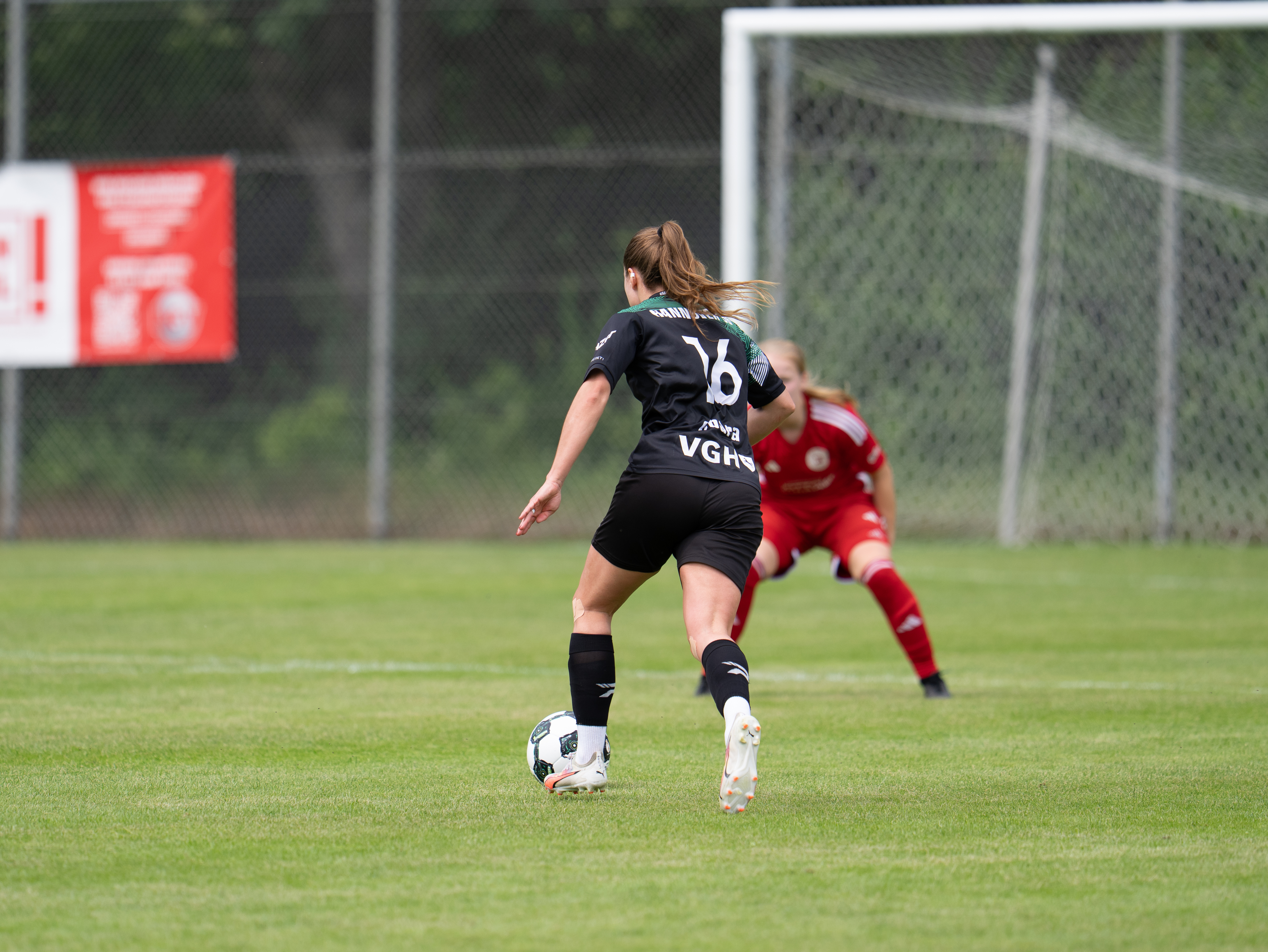 Eine Spielerin läuft mit dem Ball auf das Tor zu.