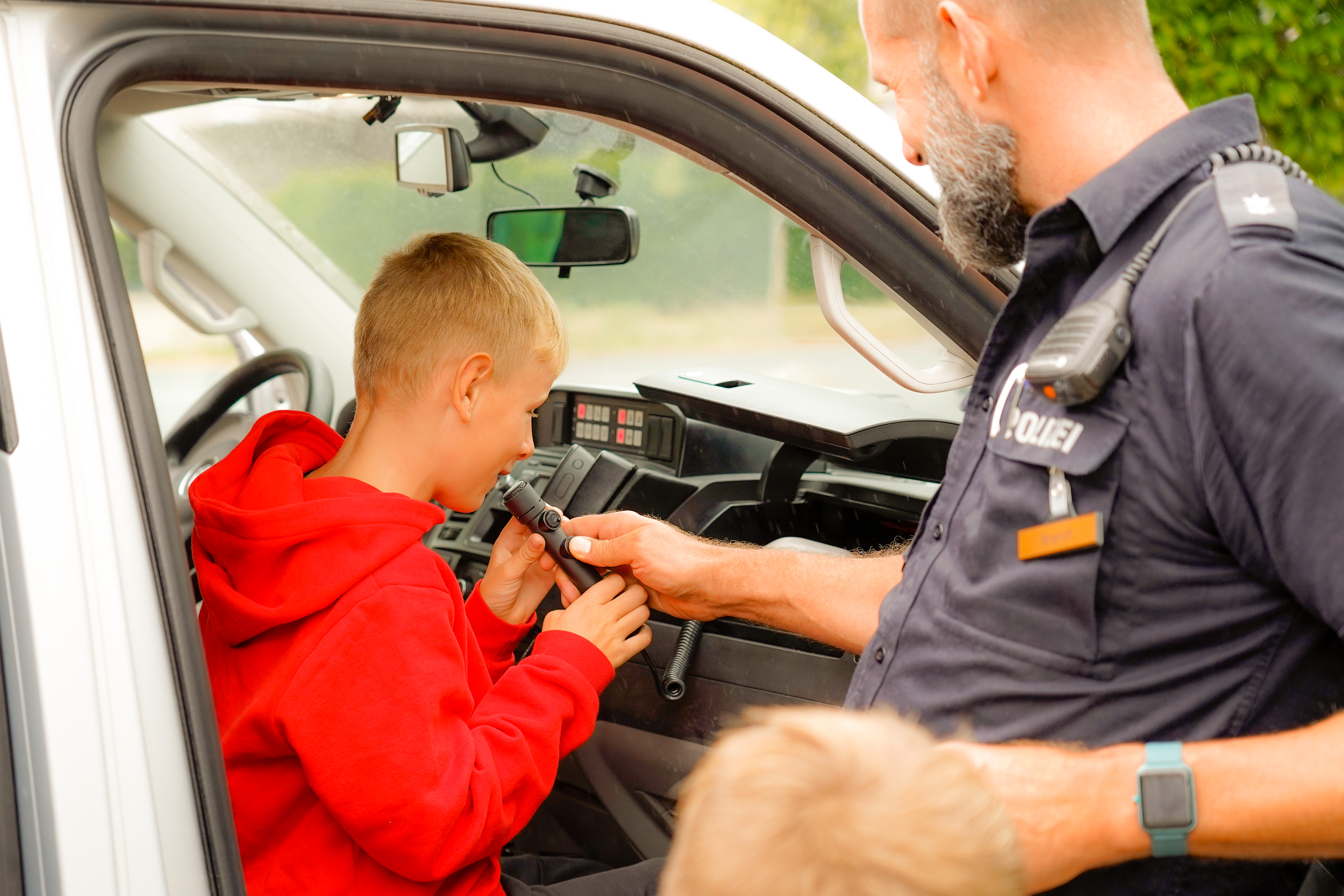 Ein Kind sitzt im Polizeiwagen.
