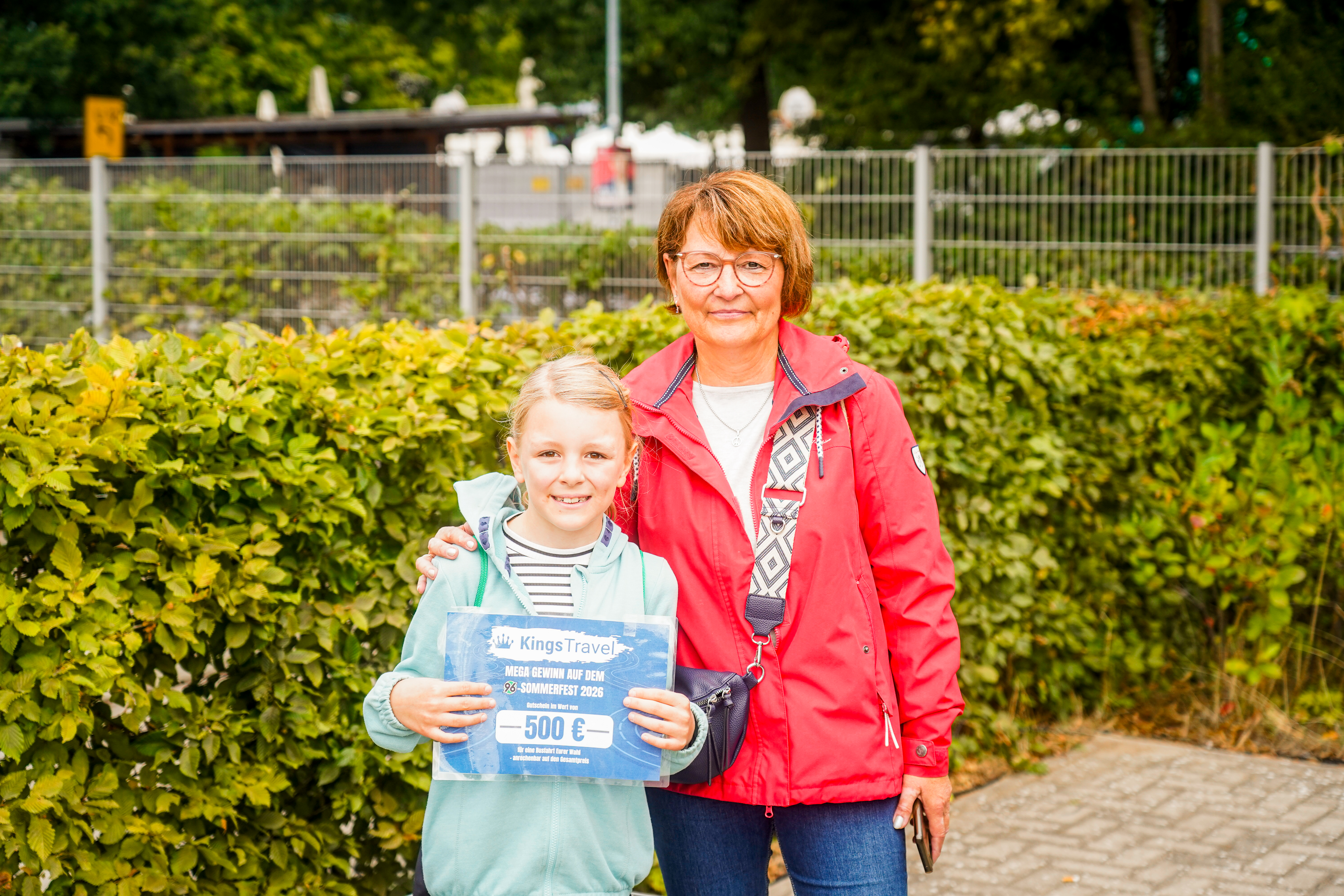 Zwei Personen halten einen Gutschein in der Hand.