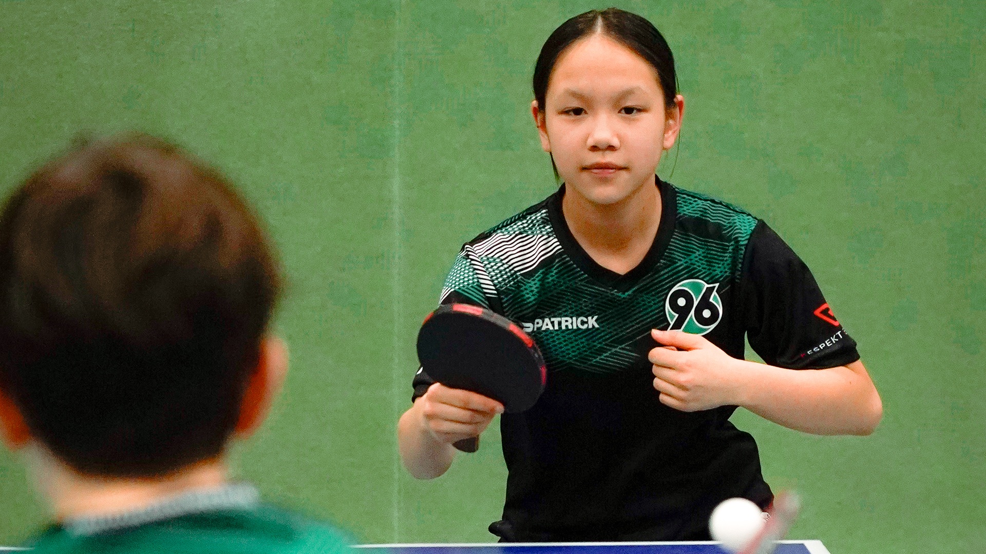 Mädchen spielt Tischtennis im 96-Trikot