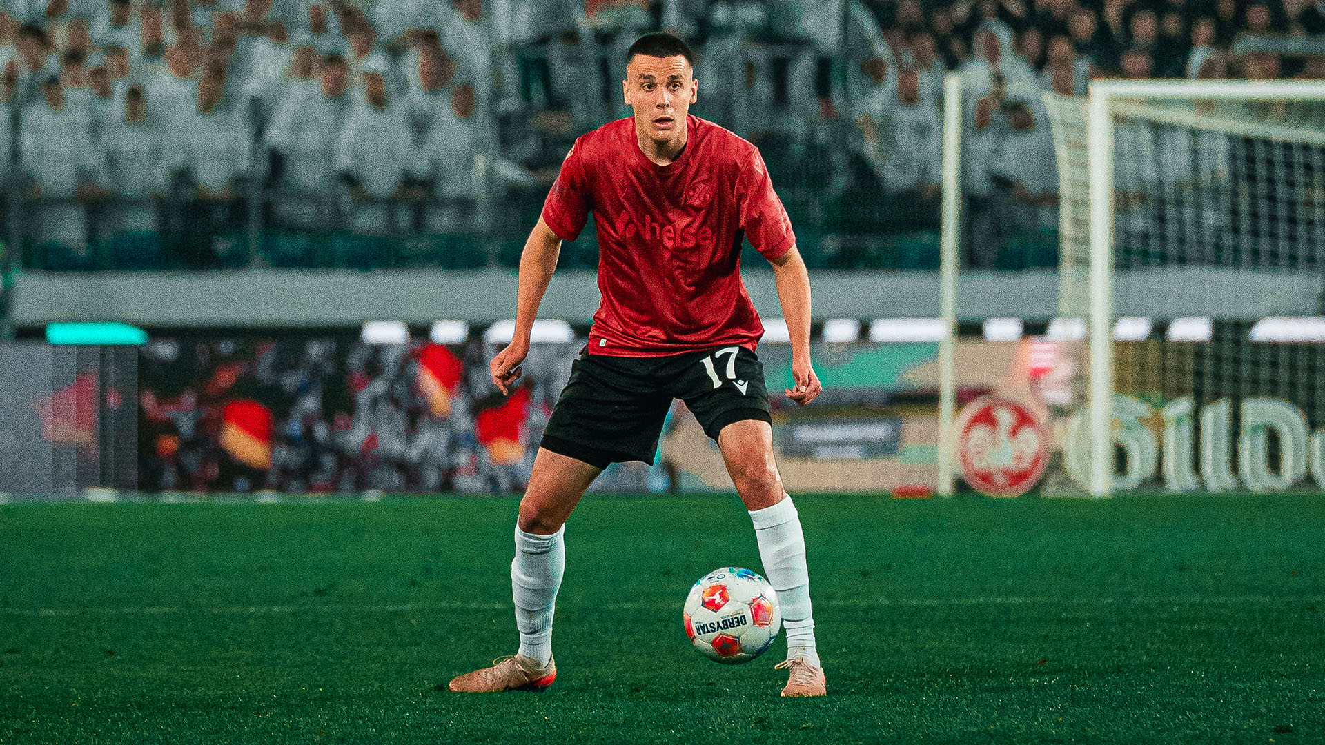 Bastian Allgeier im roten Sondertrikot am Ball.