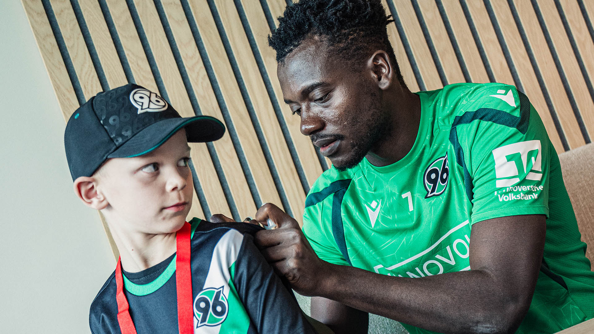 Mustapha Bundu unterschriebt Trikot.