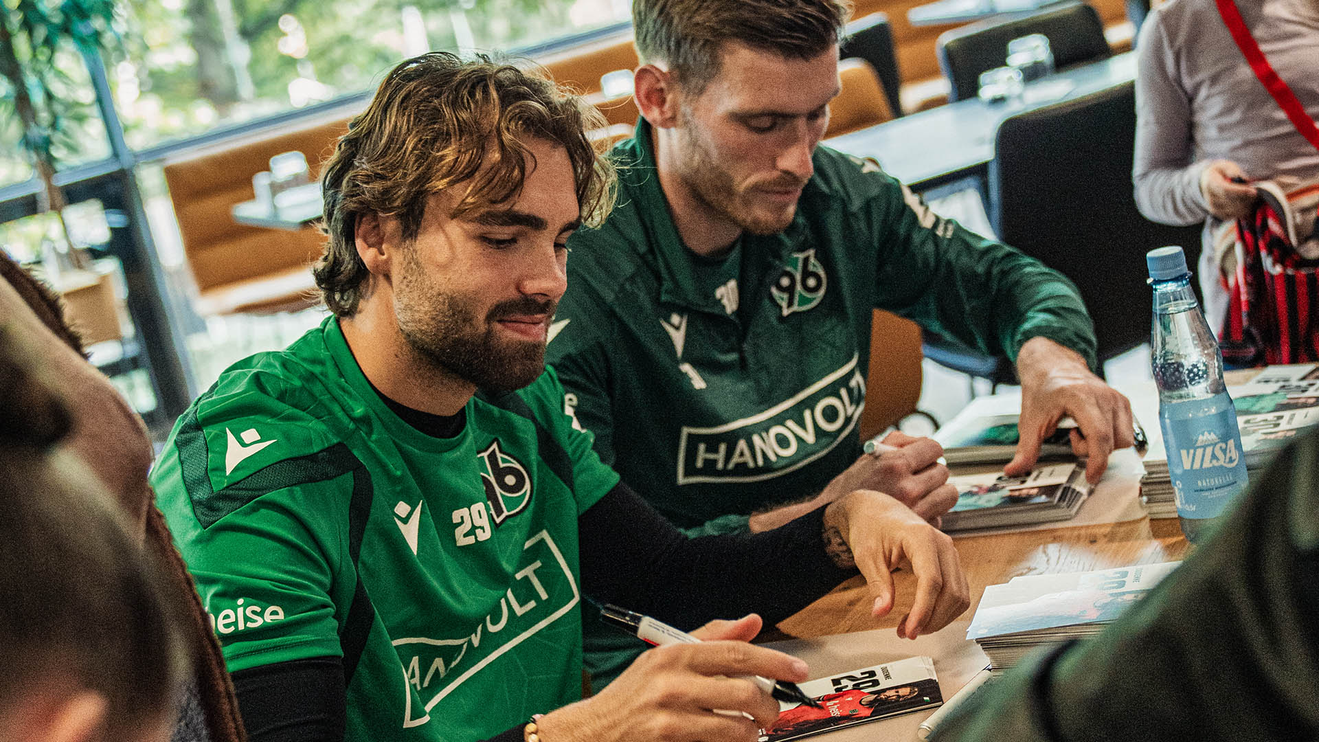 Kolja Oudenne & Leo Weinkauf unterschreiben Autogrammkarten.