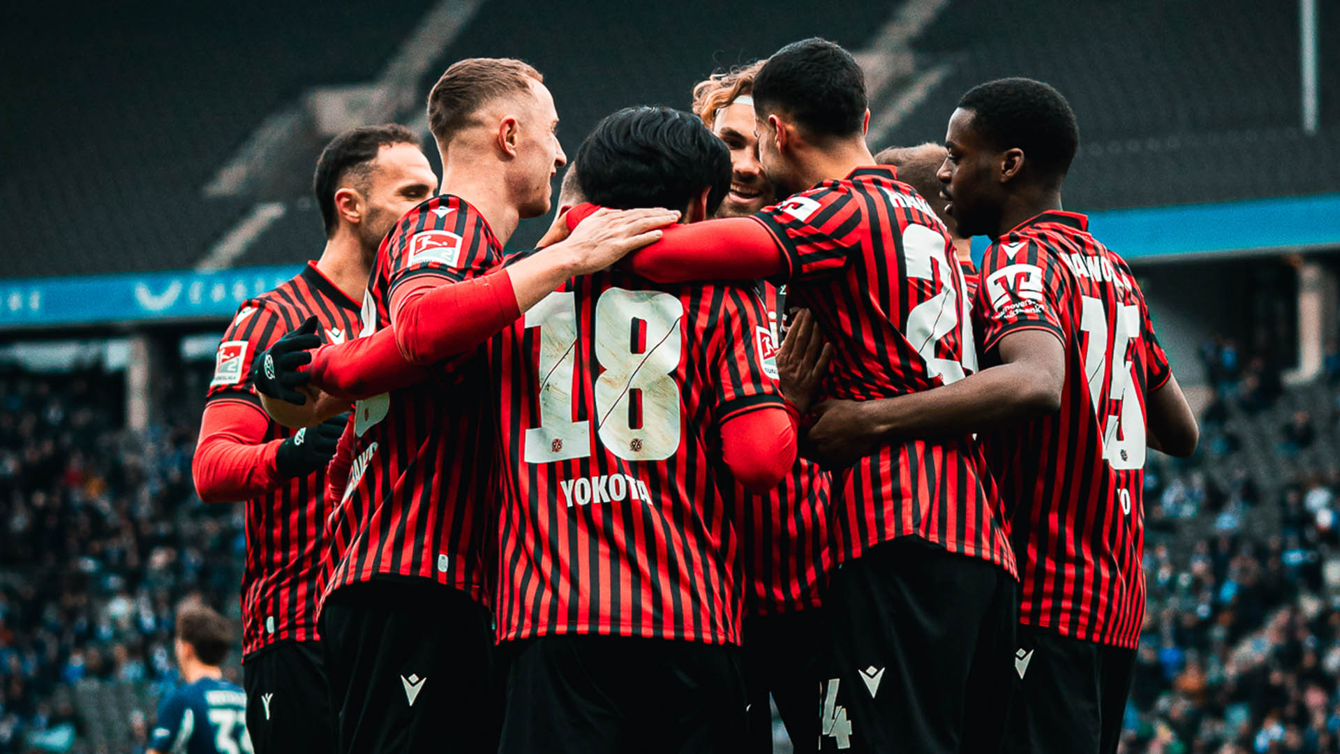 Eine Jubeltraube aus 96-Spielern in roten Trikots.