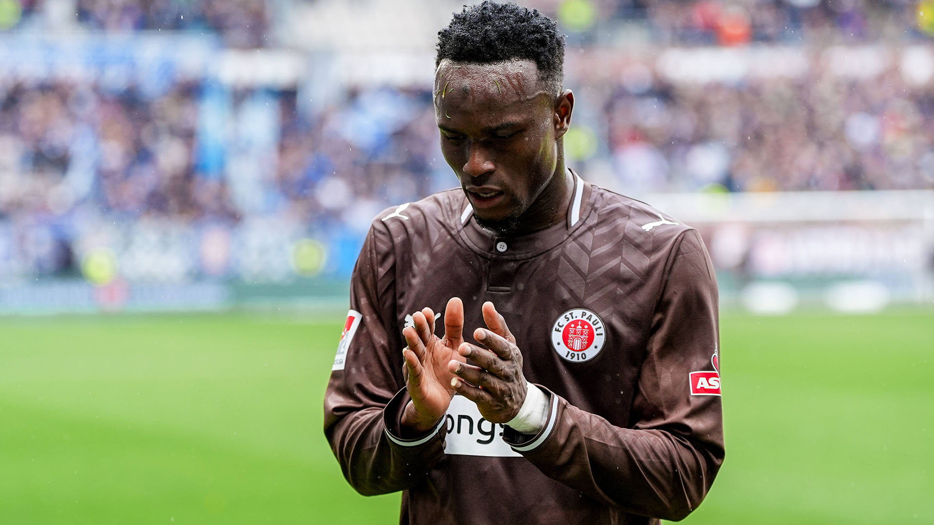 Abdoulie Ceesay klatscht und schaut auf den Boden.