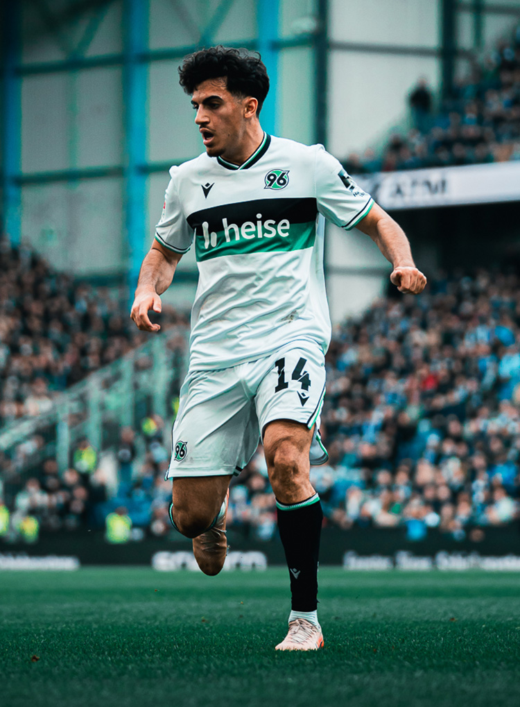 Husseyn Chakroun im weißen 96-Trikot auf dem Rasen.