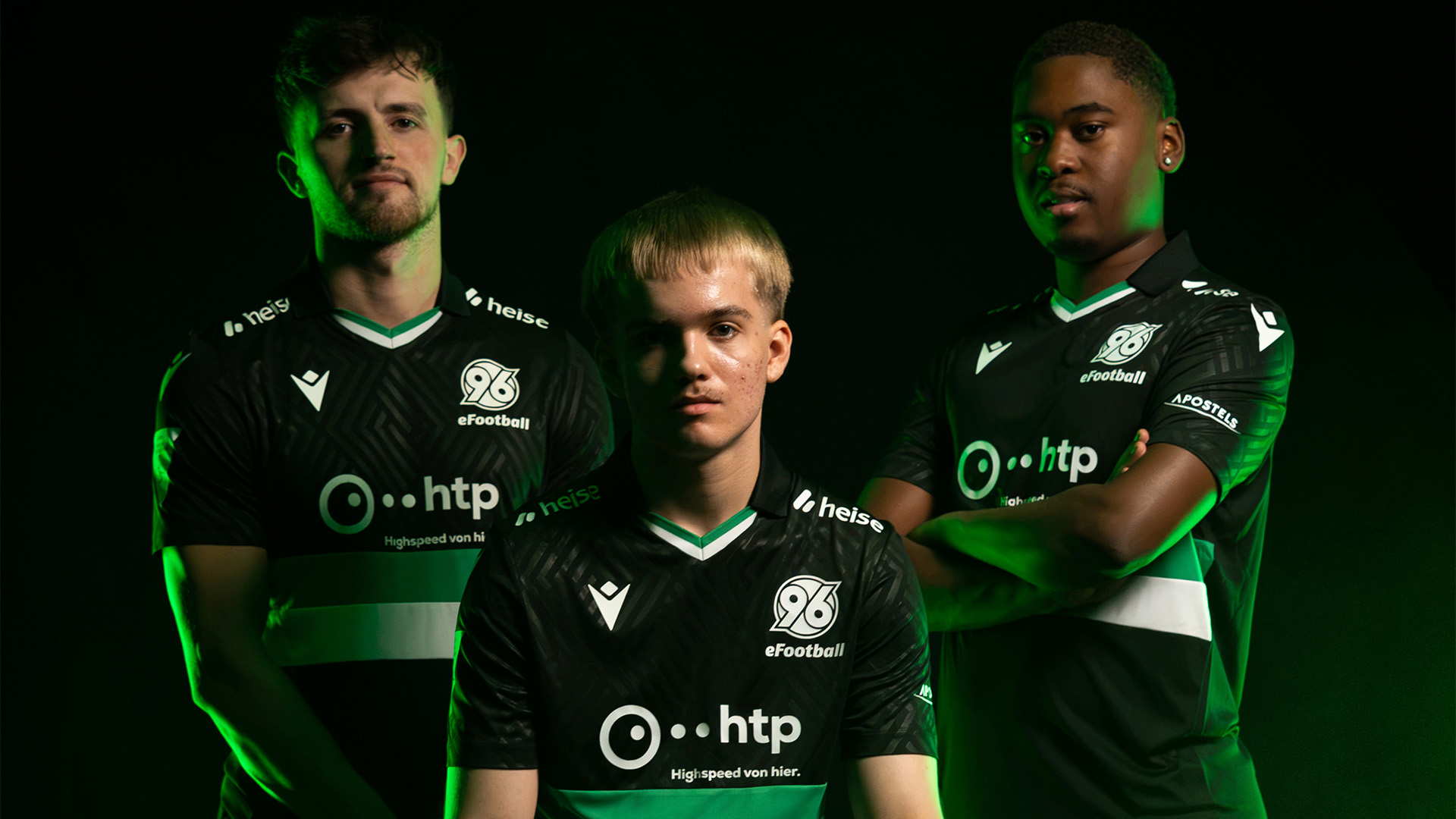 Die drei eFootball-Spieler vor schwarzem Hintergrund, einer sitzt auf einer silbernen Kiste, zwei stehen.