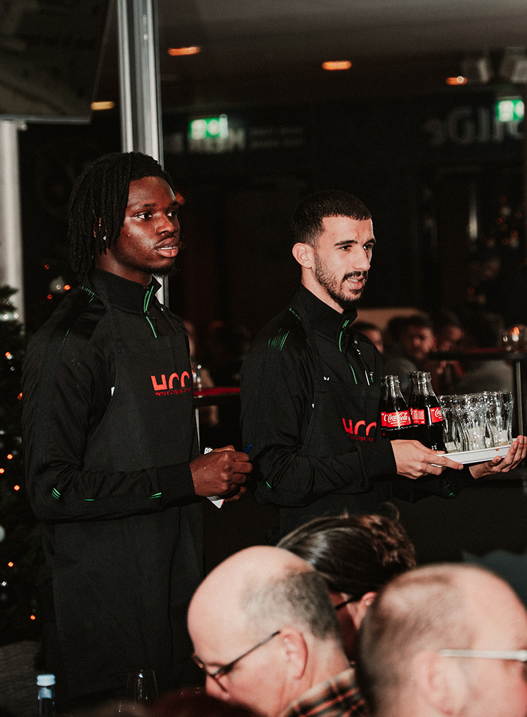 Blank und Taibi mit Getränken in der Hand. 