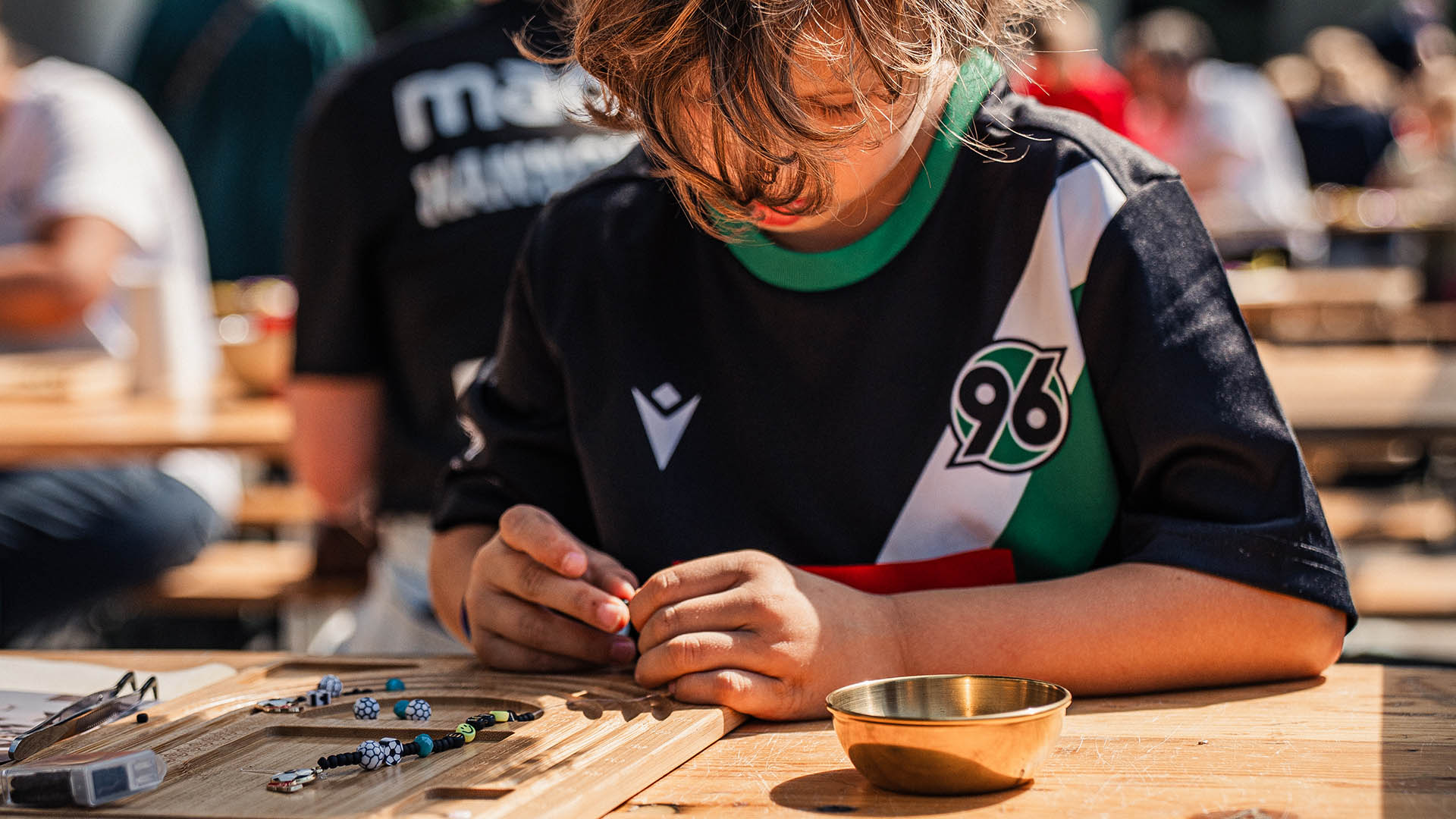 Kind bastelt Freundschaftsband.