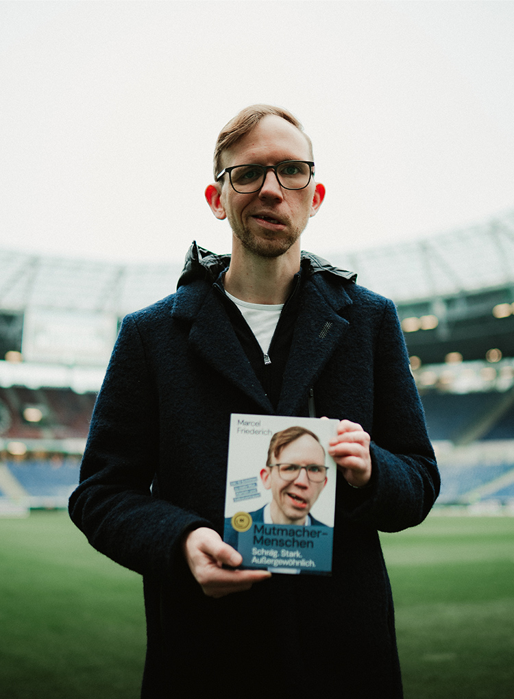 Marcel Friederich im 96-Stadion mit seinem Buch in der Hand.