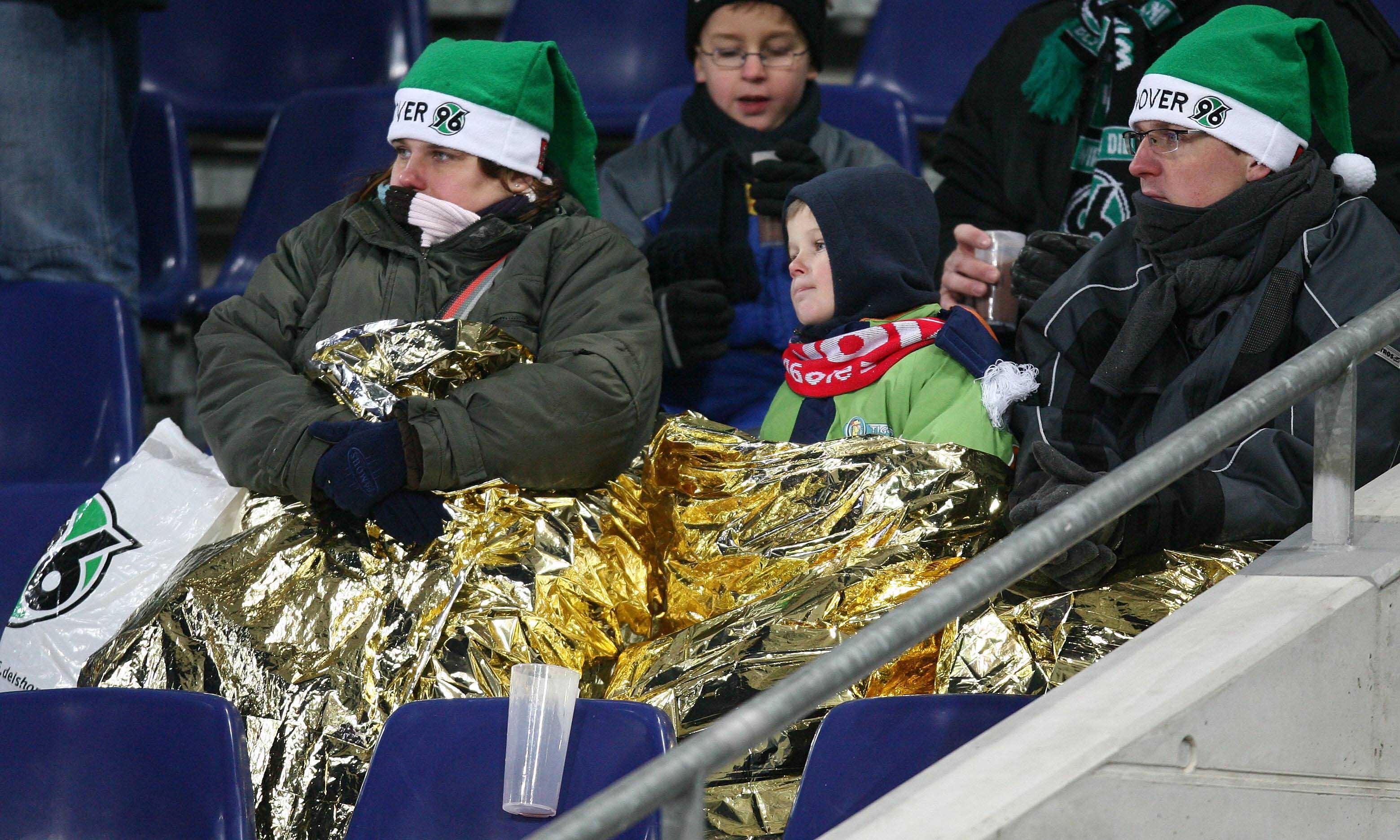 Fans hüllen sich in Thermodecken.