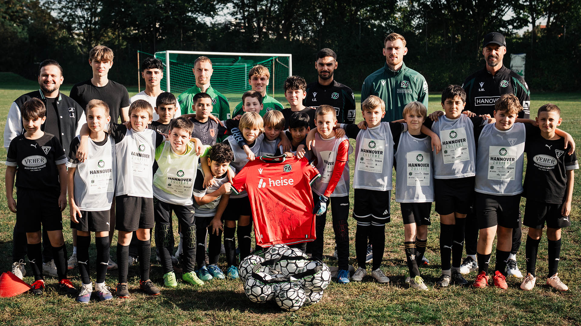 Gruppenfoto mit den Kids eines Fußabllvereins und 96-Profis.