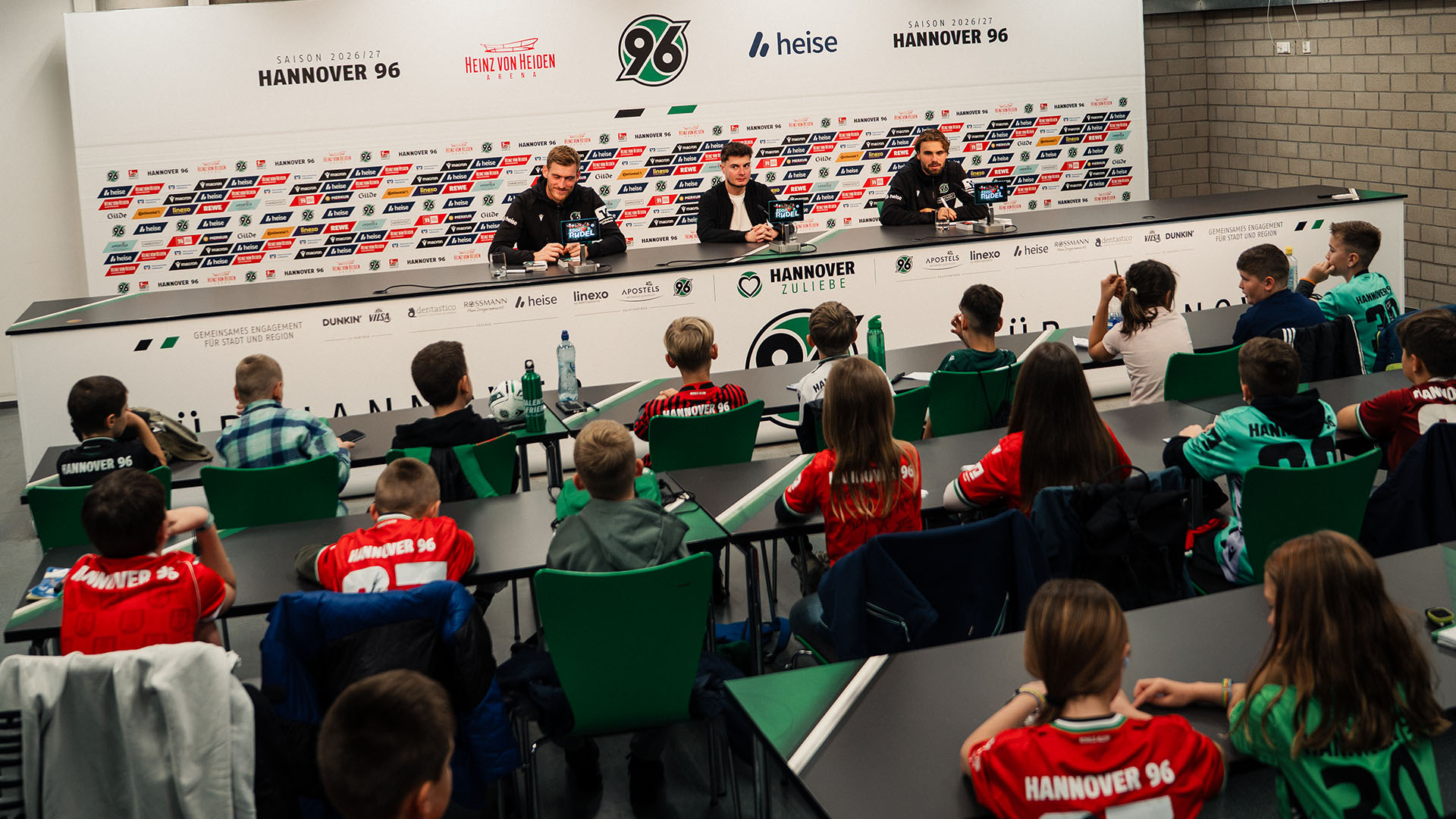Leo Weinkauf und Kolja Oudenne sitzen im PK-Raum vor 30 Kindern.