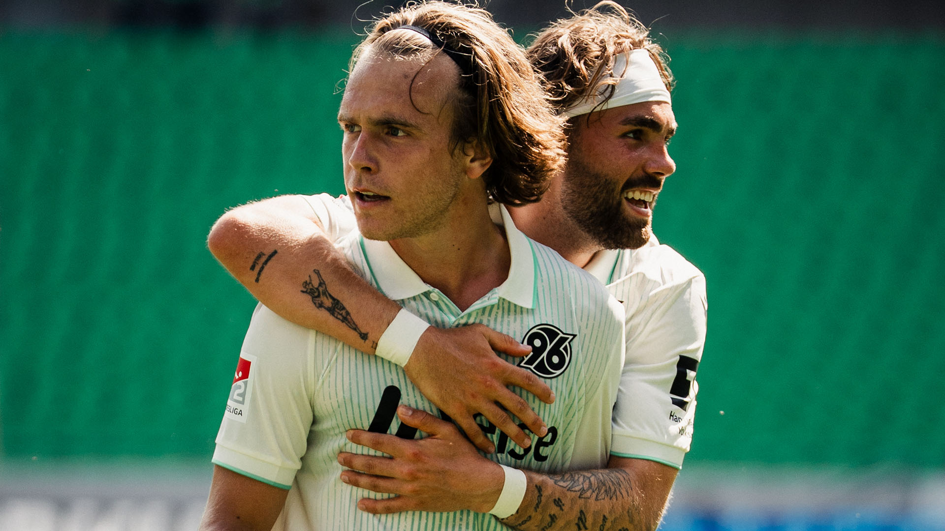 Kolja Oudenne umarmt Lars Gindorf von hinten. 