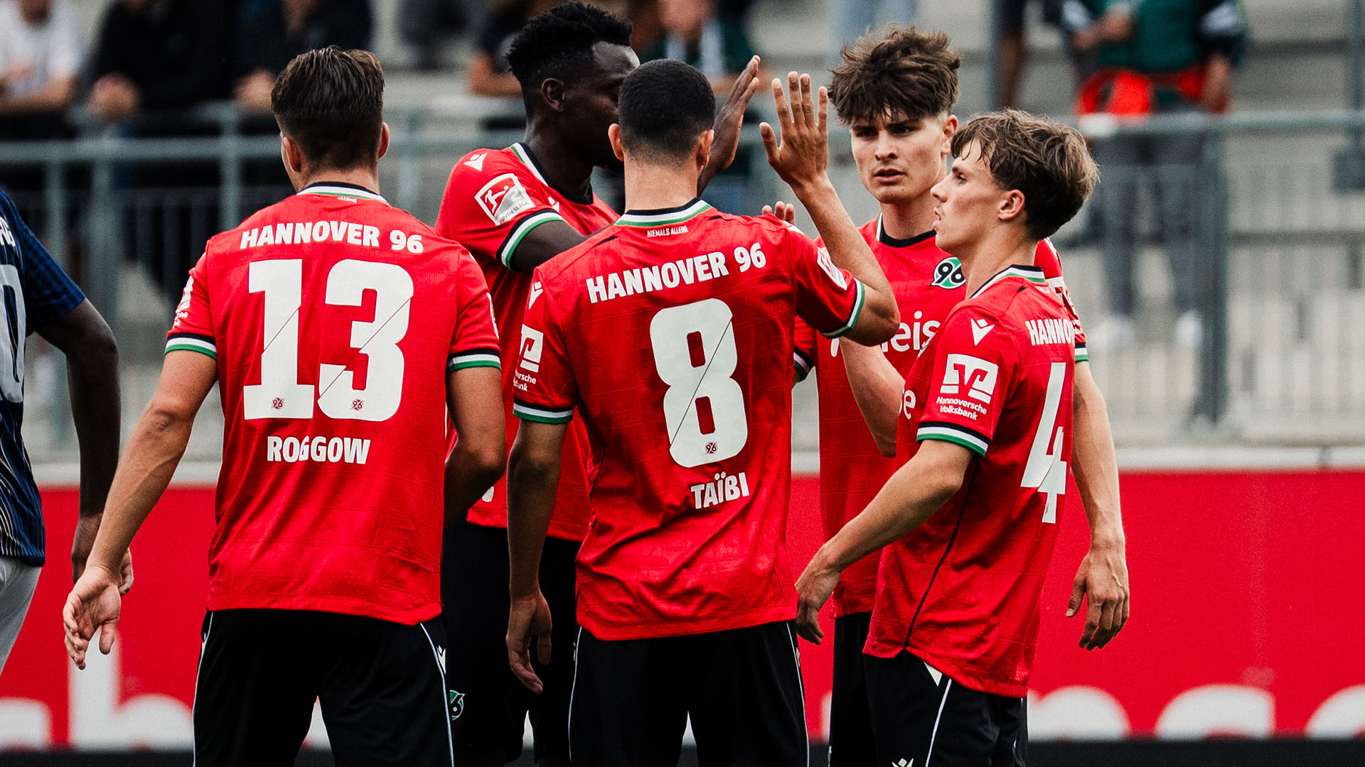 Jubelnde 96-Spieler im roten Trikot.