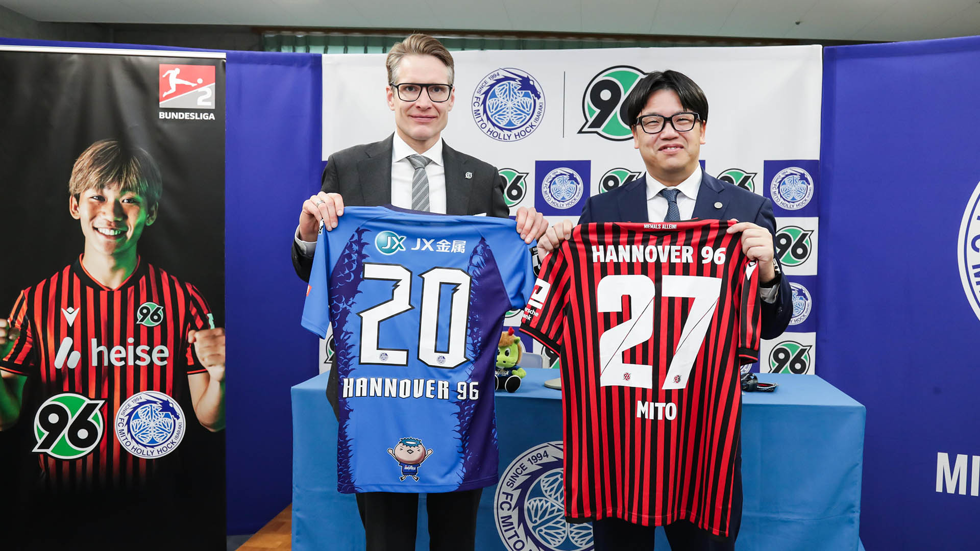 Henning Bindzus (links) und Ko Kojima (rechts) halten Trikots hoch. 