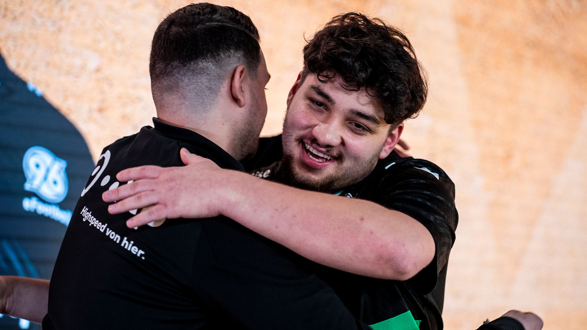 eFootballer Musti umarmt Coach Paddy freudig nach einem Sieg.