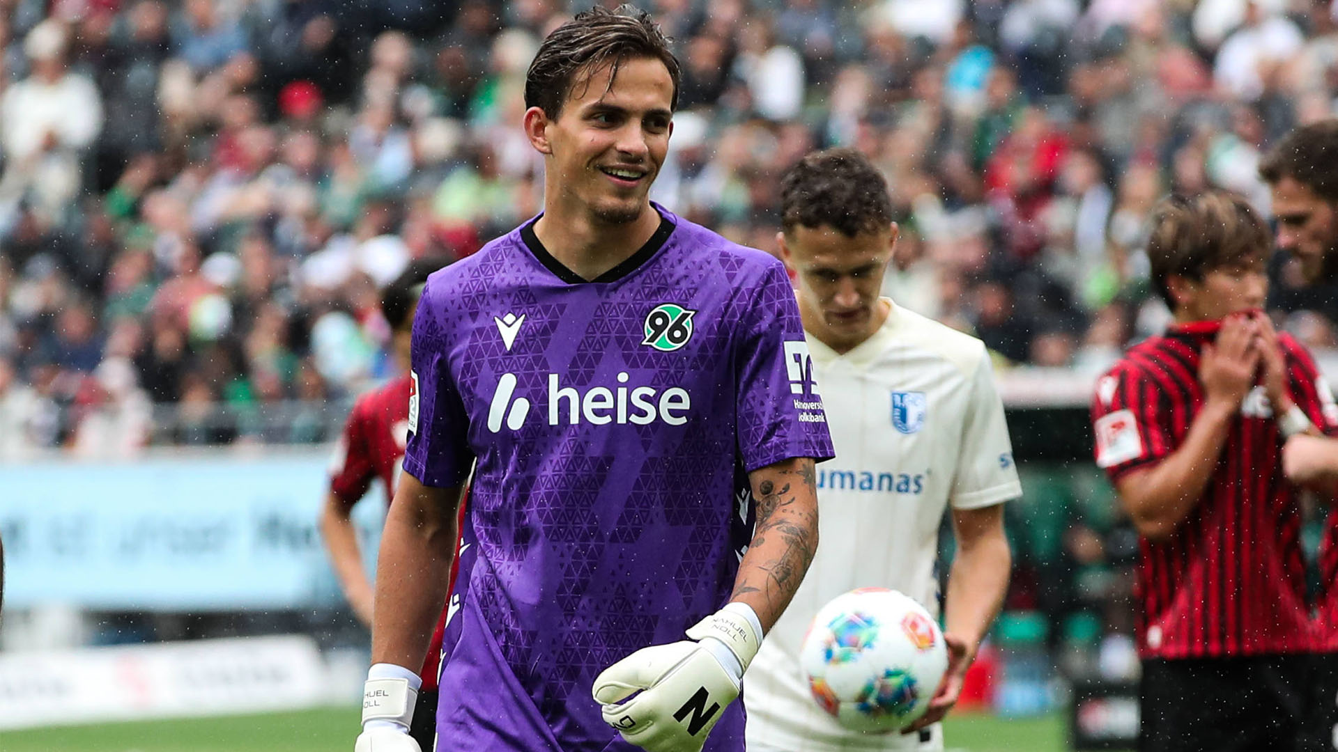 Nahuel Noll im lilanen Trikot mit einem Lächeln.