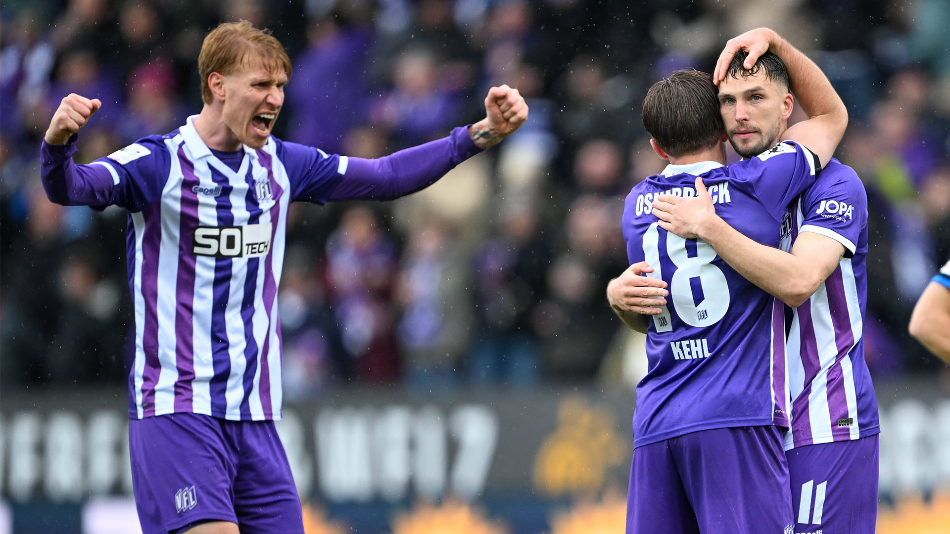 Drei Osnabrück Spieler in lilanen Trikots.