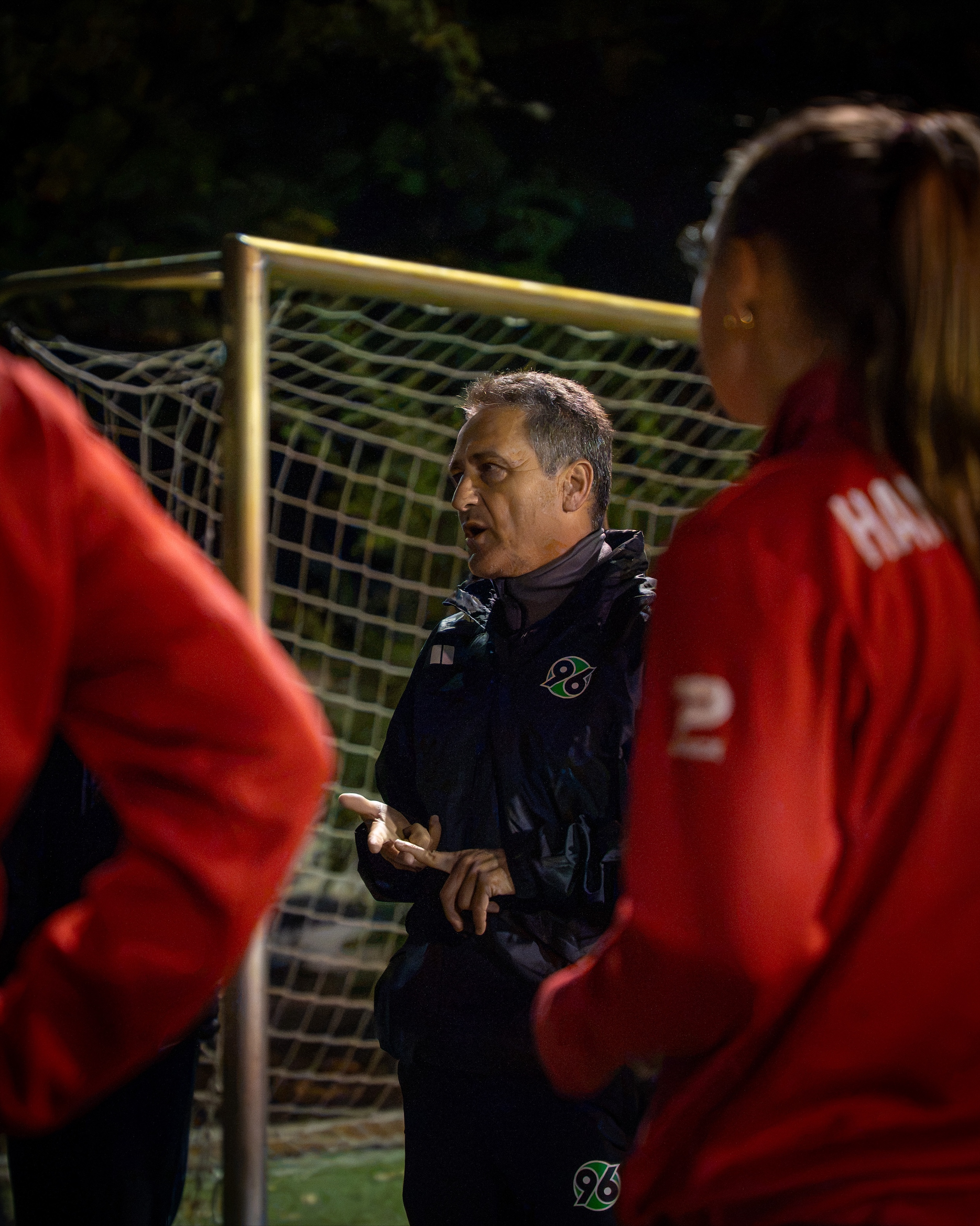 Trainer hält eine Ansprache an seine Spielerinnen.