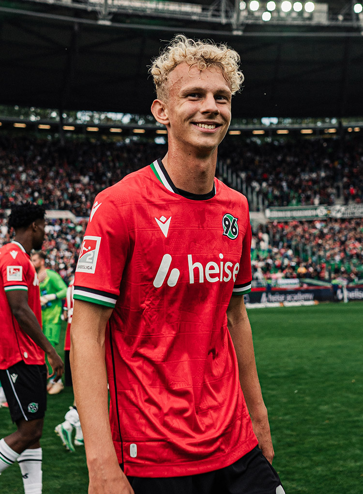 Jasper Reinhold lacht im roten Trikot in die Kamera.