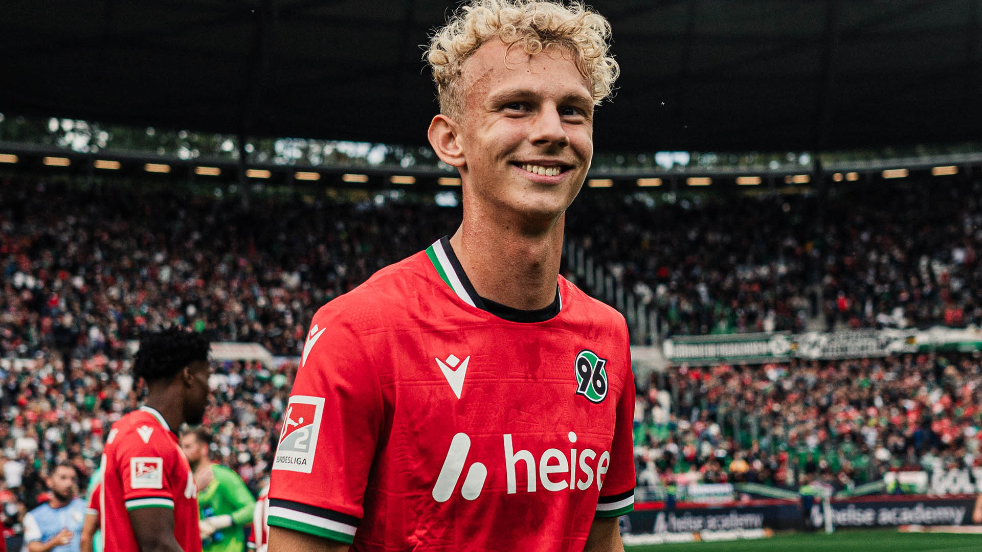 Jasper Reinhold lacht im roten Trikot in die Kamera.
