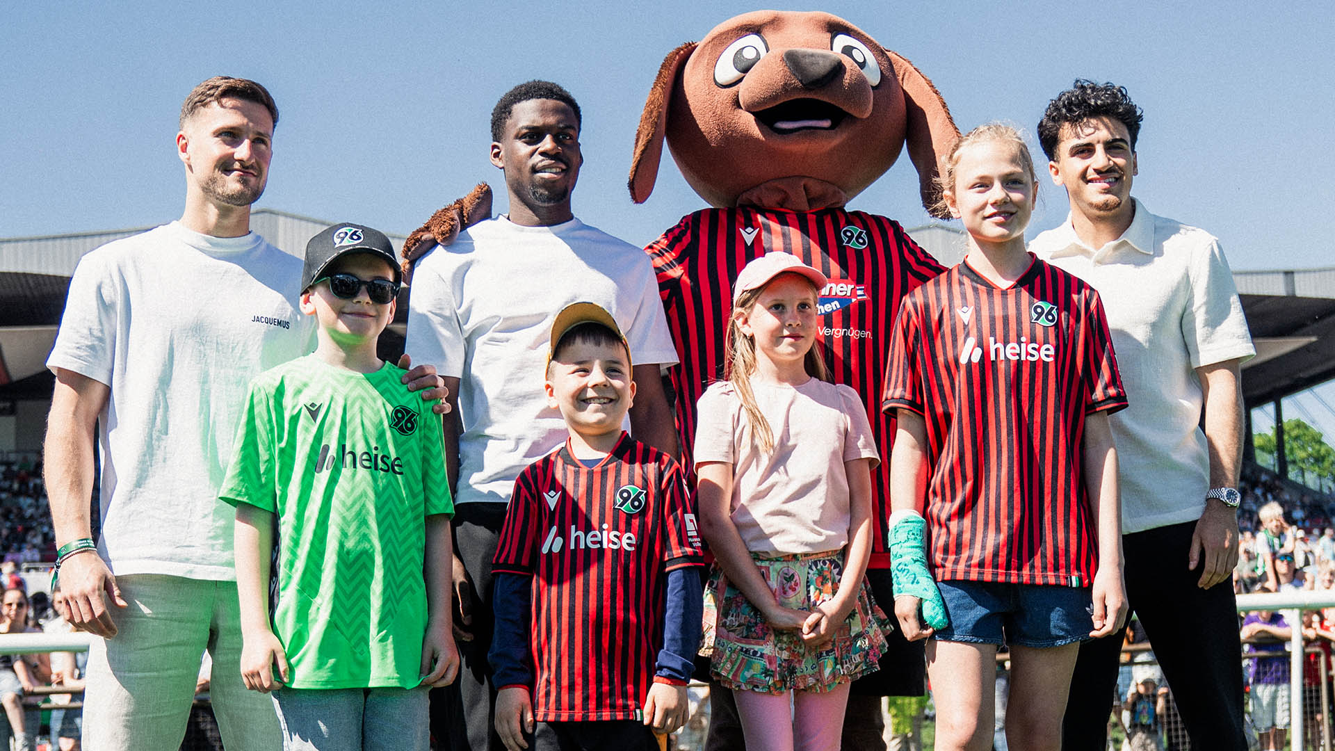 Enzo Leopold, Noel Aseko und Husseyn Chakroun mit Maskottchen Eddi und vier Kindern.