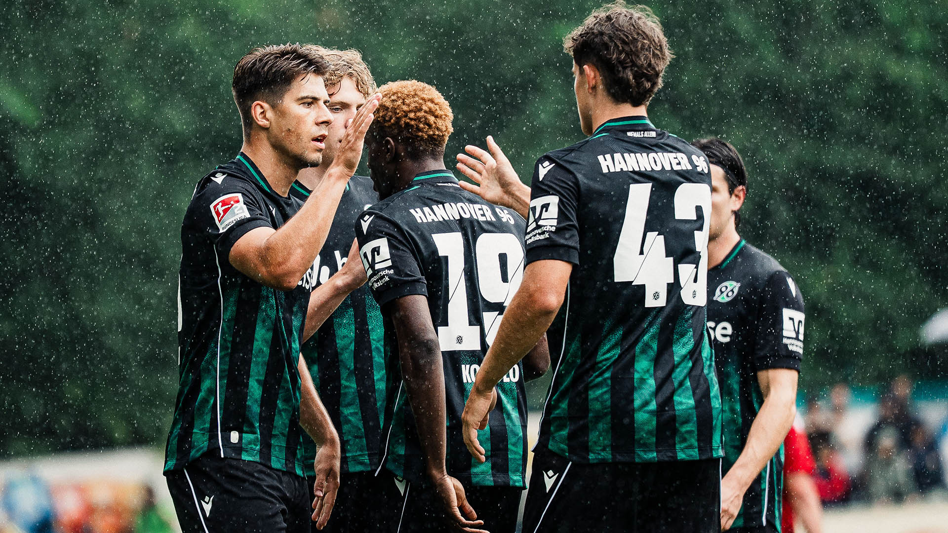 Jubeltraube von 96-Spielern in dunklen Trikots.