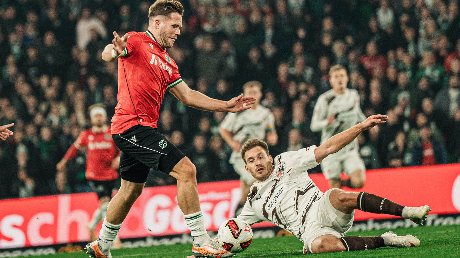 Benjamin Källman am Ball, ein St. Paulianer grätscht.