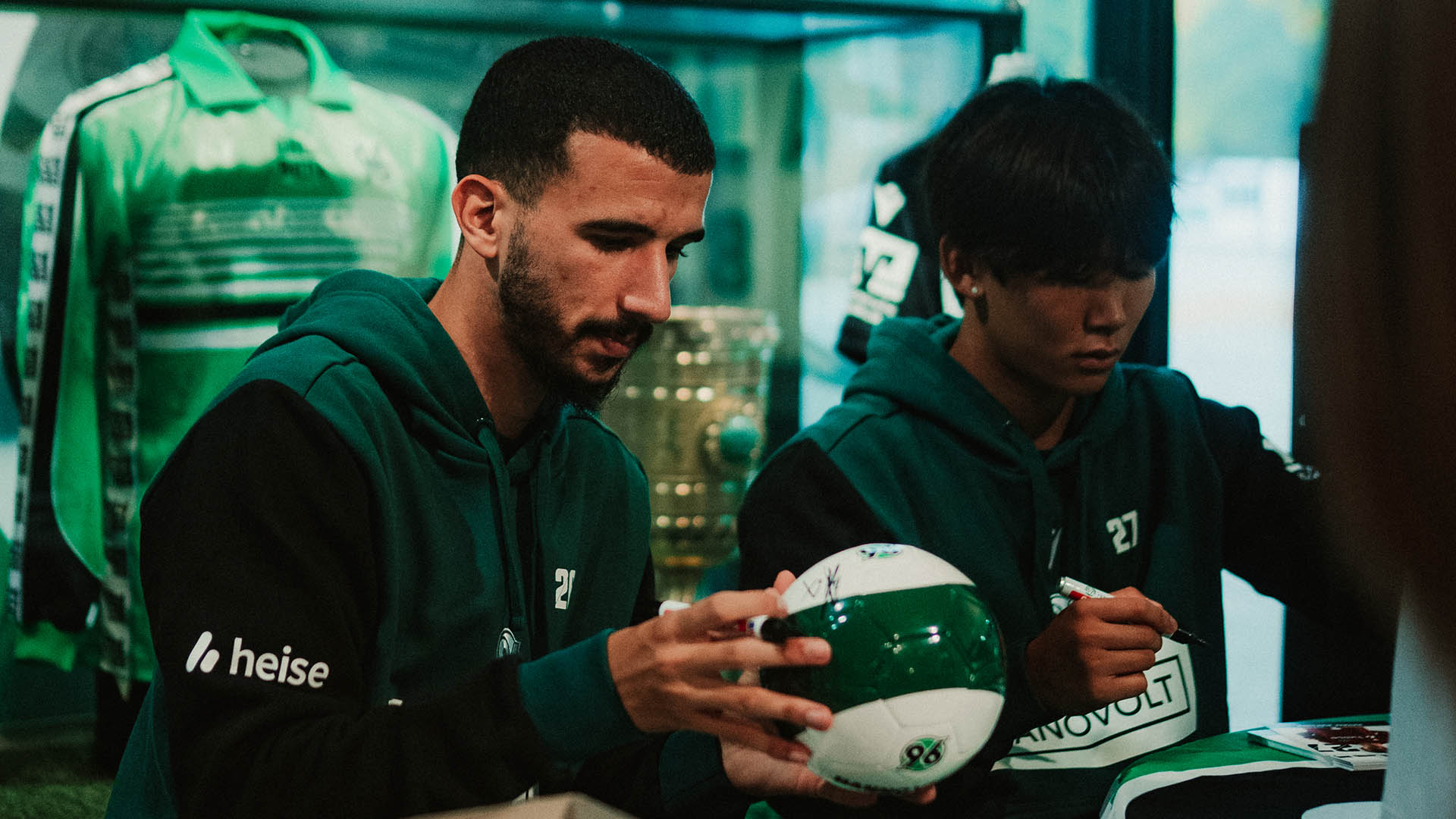 Waniss Taibi und Hayata Matsuda schreiben Autogramme.