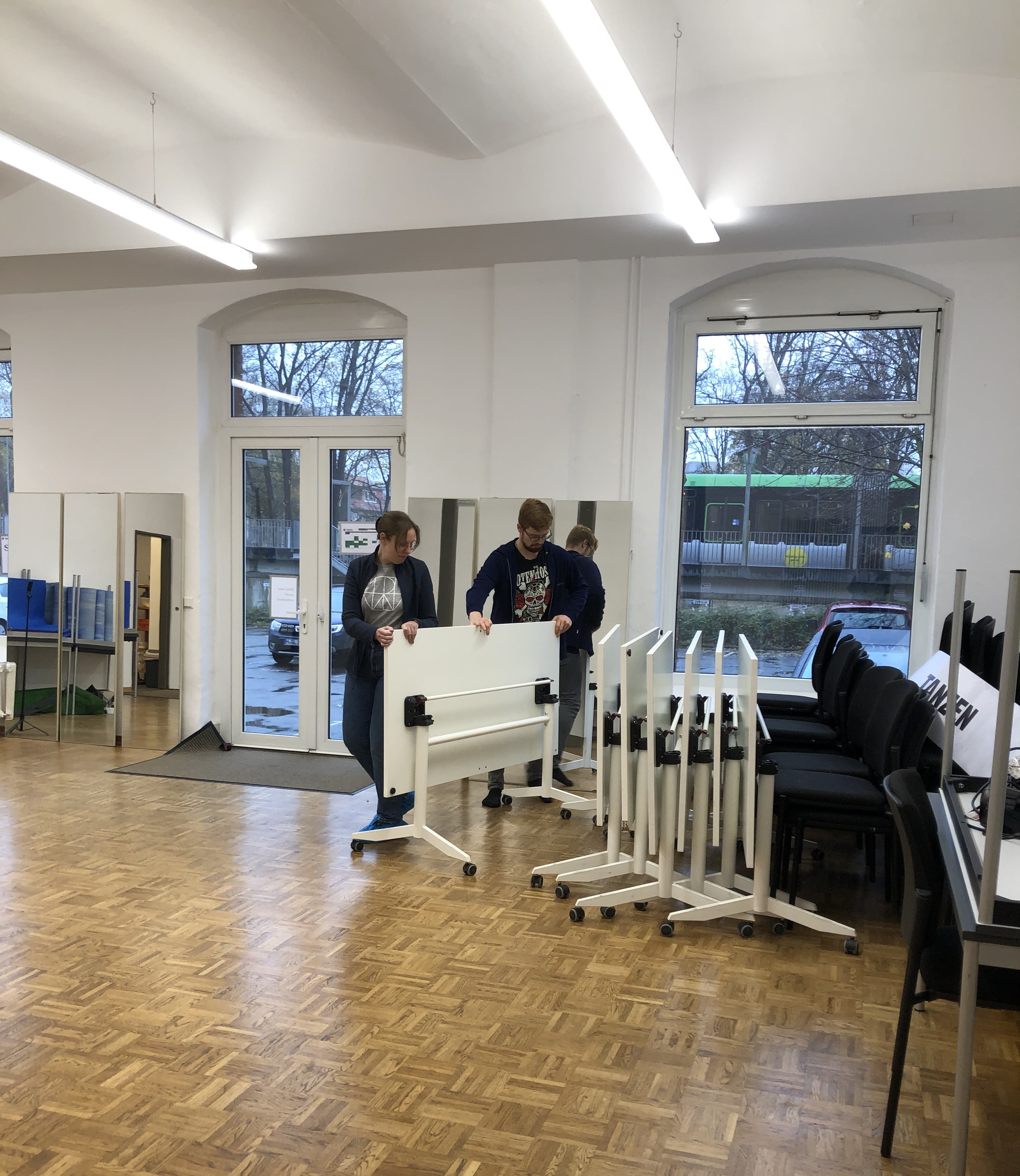 Zwei Personen schieben einen Tisch.